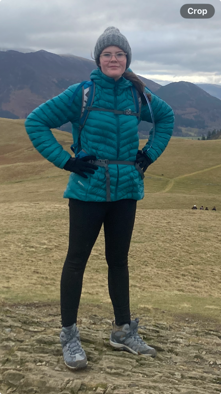Edie on a hillside in her hiking gear, ready for the challenge